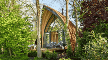 Huisje in de vorm van een druppel in het bos.