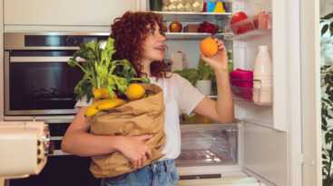 Ginger girl unpacking food in the kitchen