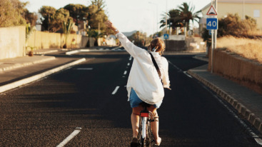 meisje voelt zich helemaal zichzelf en fietst vrolijk door de straten