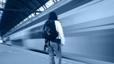 Train speeding by standing woman