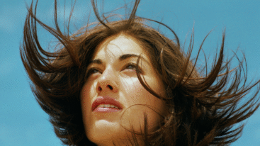 close-up van het gezicht van een vrouw met de haren in de wind