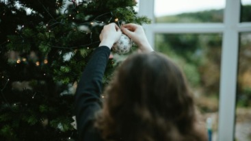 vrouw hangt kerstversiering op