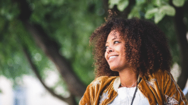 foto van vrolijke en tevreden vrouw die op straat loopt