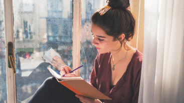 vrouw reflecteert op het jaar en schrijft in een boekje