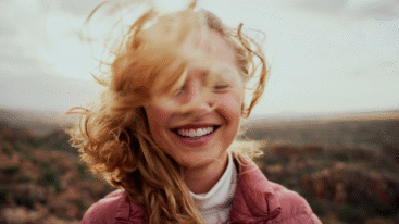 vrouw heeft ogen gesloten en lacht gelukkig