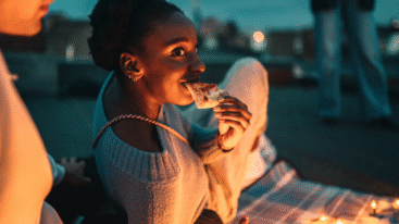 foto van een vrouw die laat op de avond pizza eet in het park