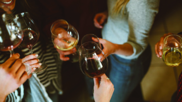 vrouwen proosten met glazen wijn