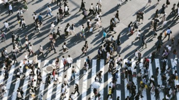 Tientallen mensen die oversteken op een groot zebrapad en van bovenaf gefotografeerd zijn