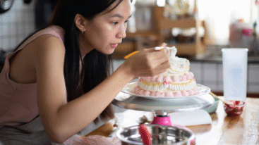Vrouw die een taart aan het decoreren is