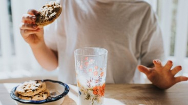 persoon is koekjes aan het eten, wat de bloedsuikerspiegel verhoogt