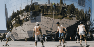 Kinderen die aan het skateboarden zijn voor Depot Boijmans Van Beuningen waarin je een weerspiegeling van de stad ziet.