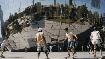 Kinderen die aan het skateboarden zijn voor Depot Boijmans Van Beuningen waarin je een weerspiegeling van de stad ziet.