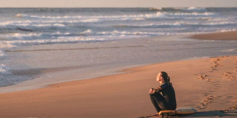 Vrouw heeft het te druk en ontspant op het strand.